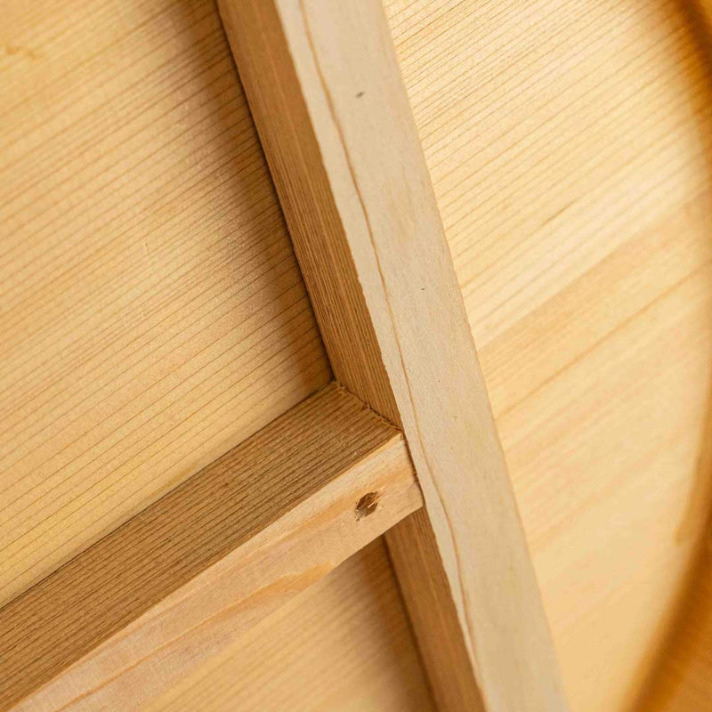 The back side of a wooden foot soaking tub, lying on its surface in a bathroom