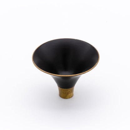 Black and gold decorative object on a white background