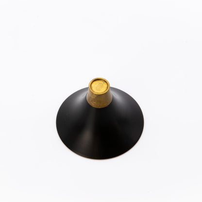 Black and gold decorative object on a white background