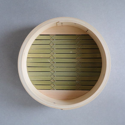 Wooden basket with green woven interior on a gray background
