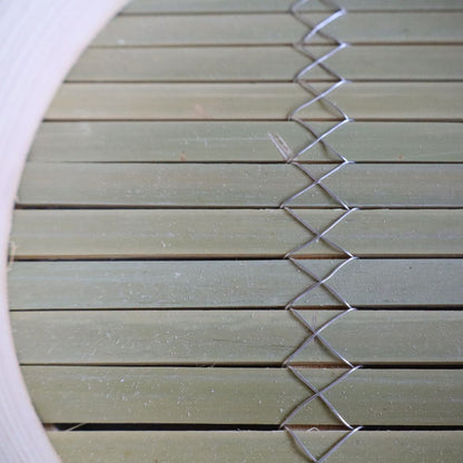 Close-up of a woven mat with a geometric pattern on a white background