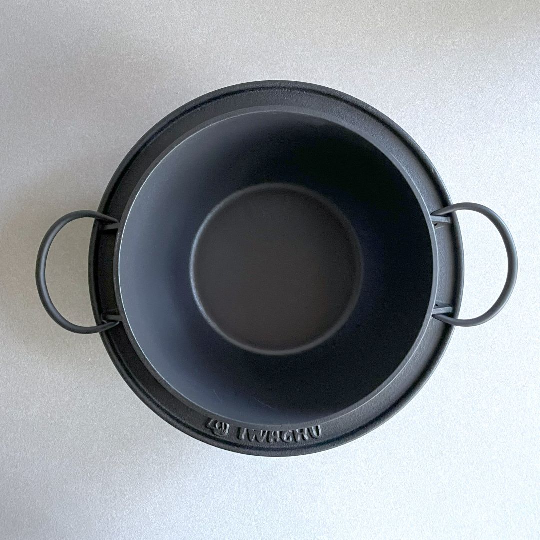 In a grey room, an upper view on a black rice pot