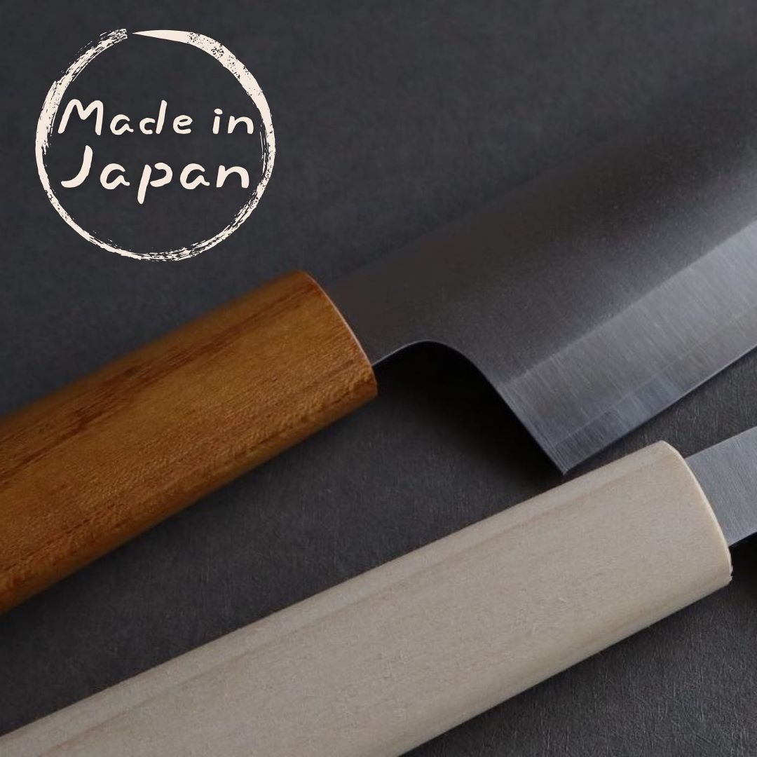 Close-up view of two Japanese knives with stainless steel blades and wooden handles, placed on a dark gray surface. The handle of the top knife is dark wood, while the bottom knife has a light wood handle. A circular 'Made in Japan' stamp is visible in the top left corner, emphasizing the origin of the knives.