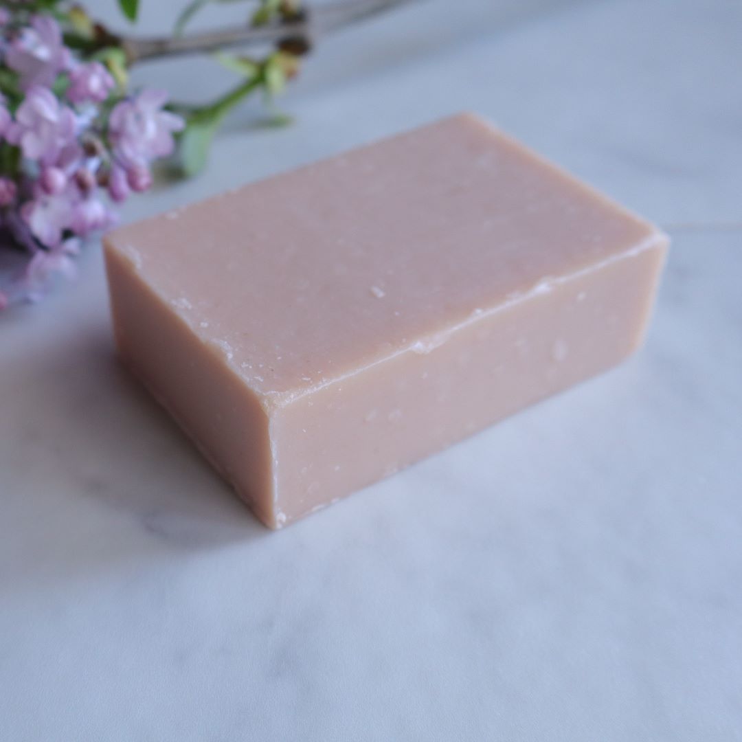 Close-up of a handmade Sakura Leaf Soap bar with a delicate pink hue, displayed on a marble surface with soft floral accents, evoking a natural and luxurious Japanese spa experience.