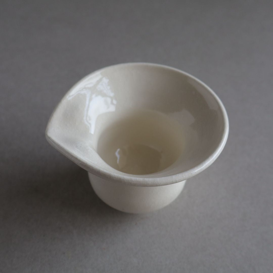 White ceramic cup on a gray background