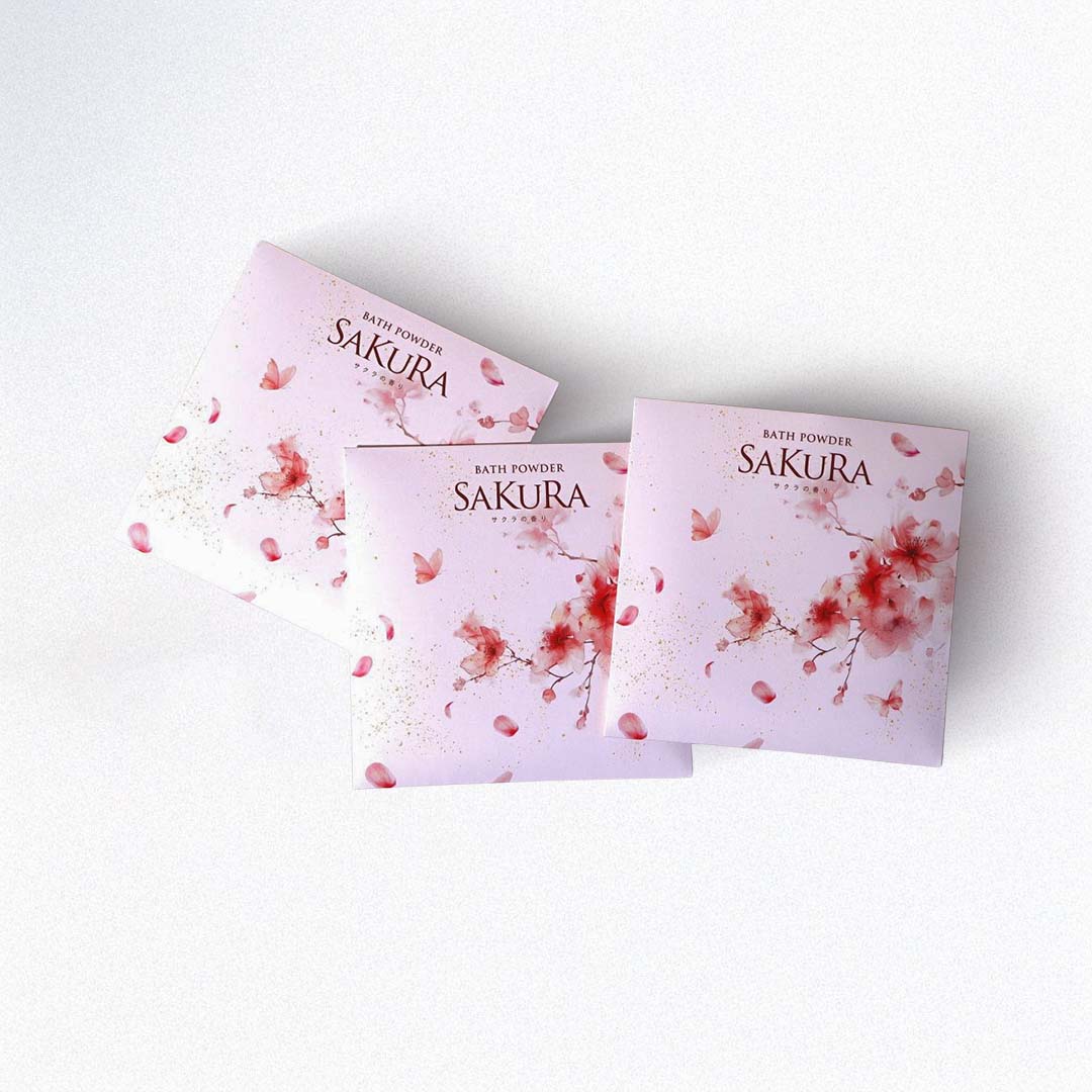 Three packages of Sakura bath powder on a white background