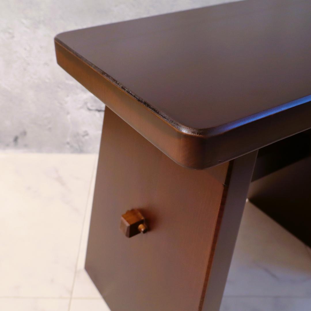 Brown wooden stool with a textured surface on a light background