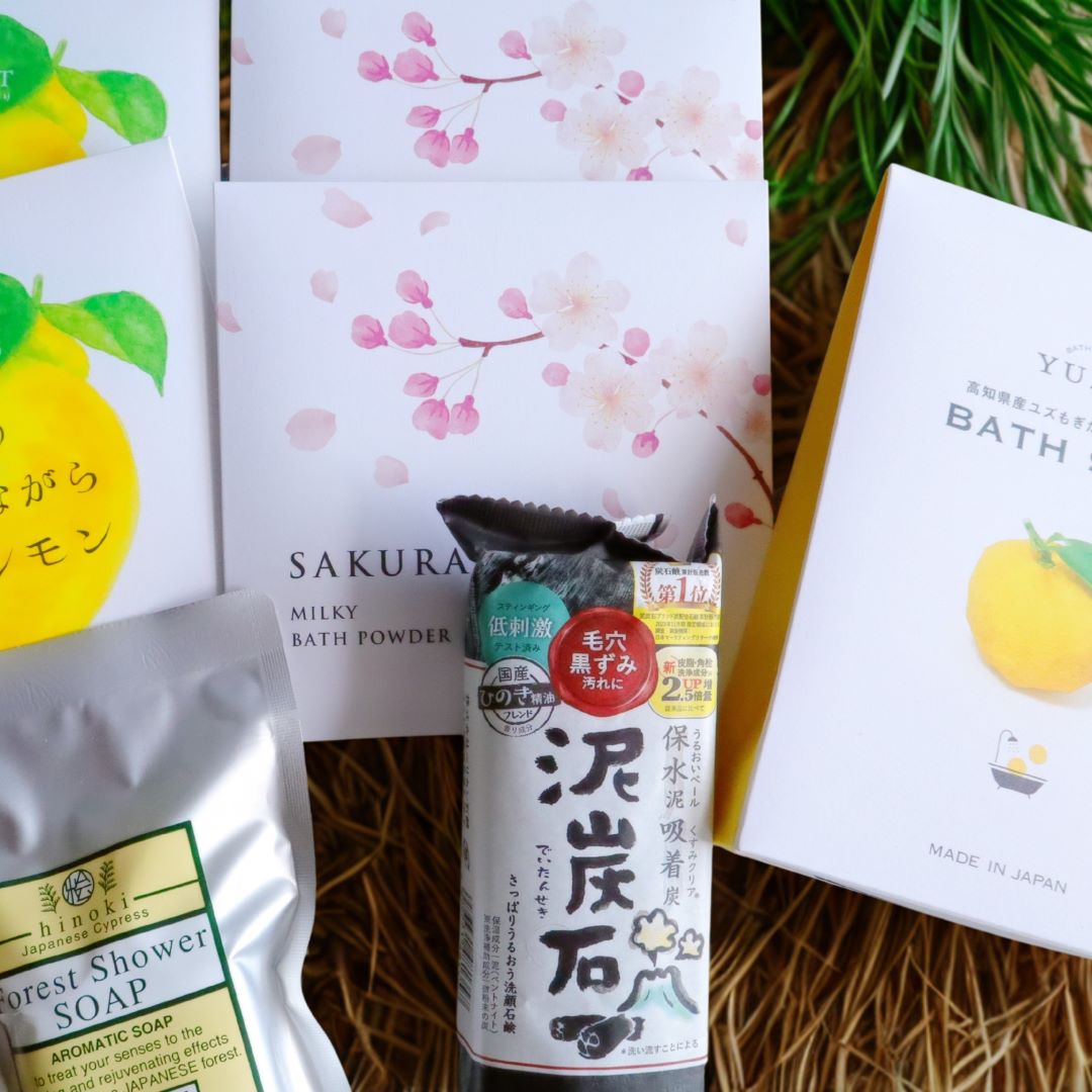 Collection of Japanese bath products including soap and bath powder on a natural background