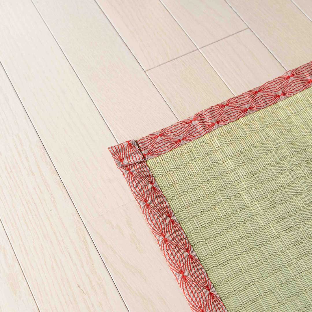 a corner of a red colour japanese tatami Ando placed on a wooden floor