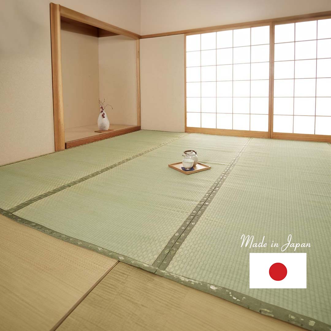 A green tatami mat made of natural rush grass covering the entire floor of a living room. A tea cup is placed in the middle of the tatami mat. A closet is seen at the bottom of the room, while a Japanese screen door is visible on the left side.
