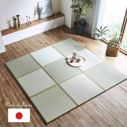 a living room with 9 tatami mat on a wooden floor with a tea set and flower plant on each side