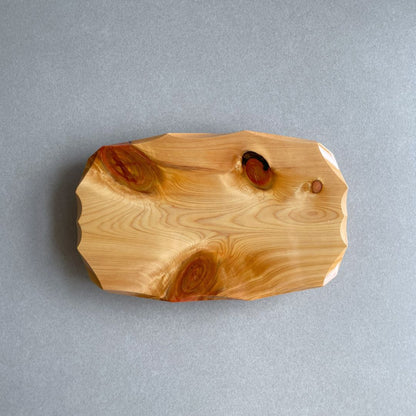 In a grey room, a wooden plate view from the top