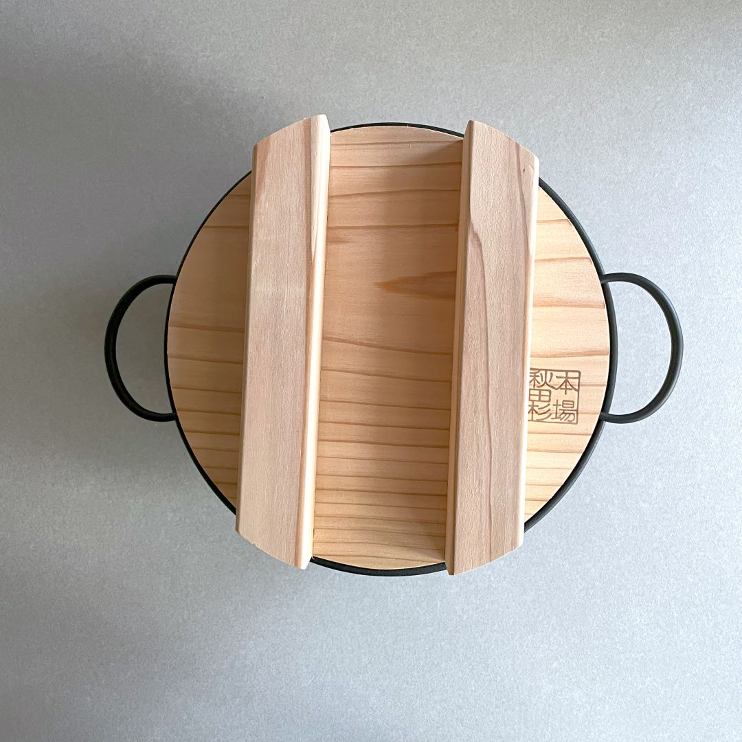 upper view of a wooden lid on a black cast iron rice pot