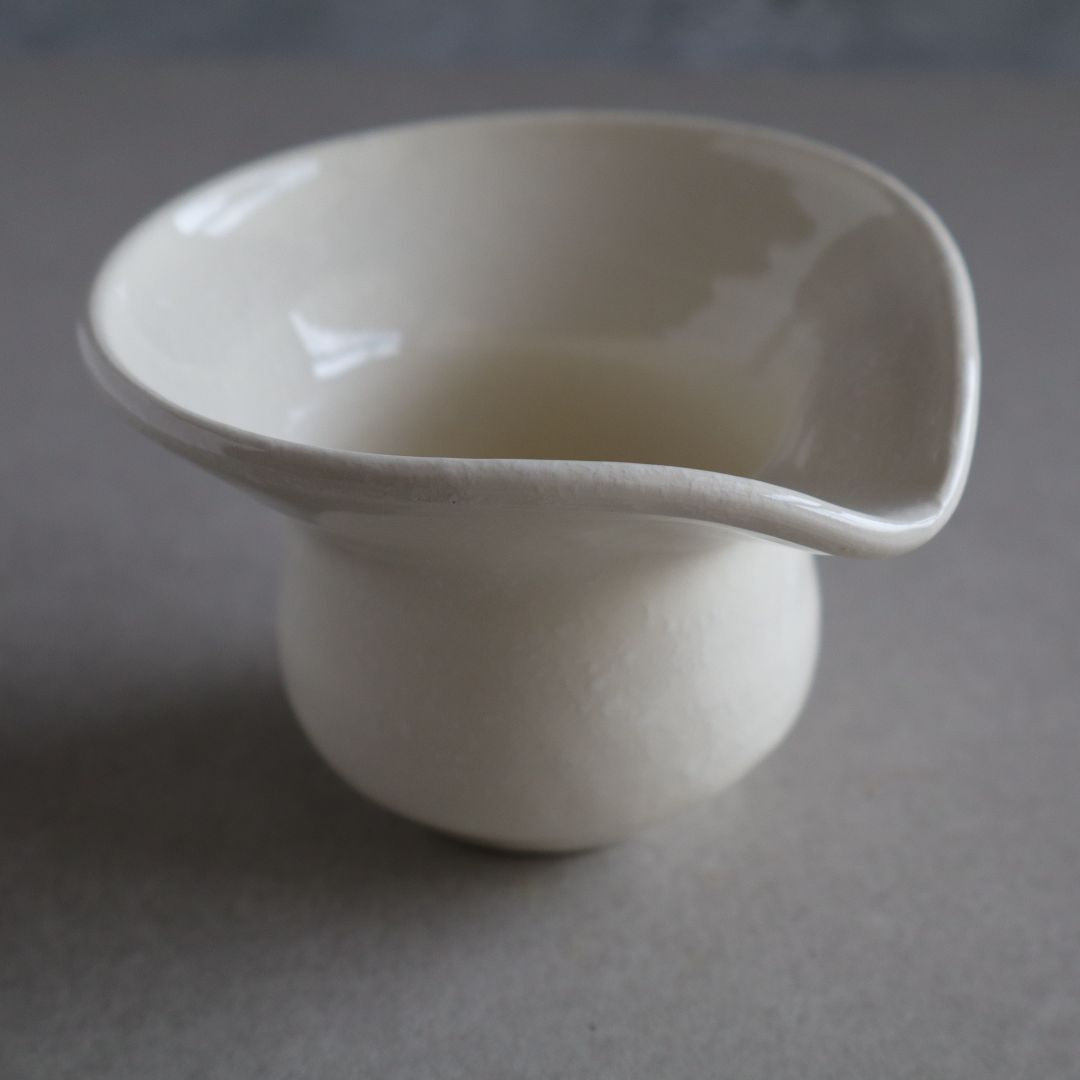 White ceramic pitcher on a gray background