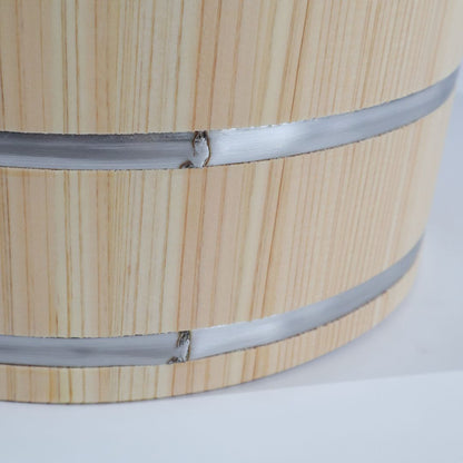 Close-up of a light natural wood cylindrical barrel or bucket with two horizontal silver metal bands around it, photographed on a white background.