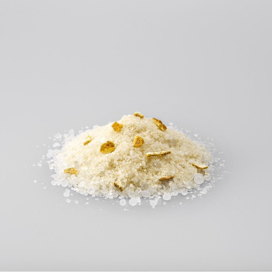 White powder with gold flecks on a gray background
