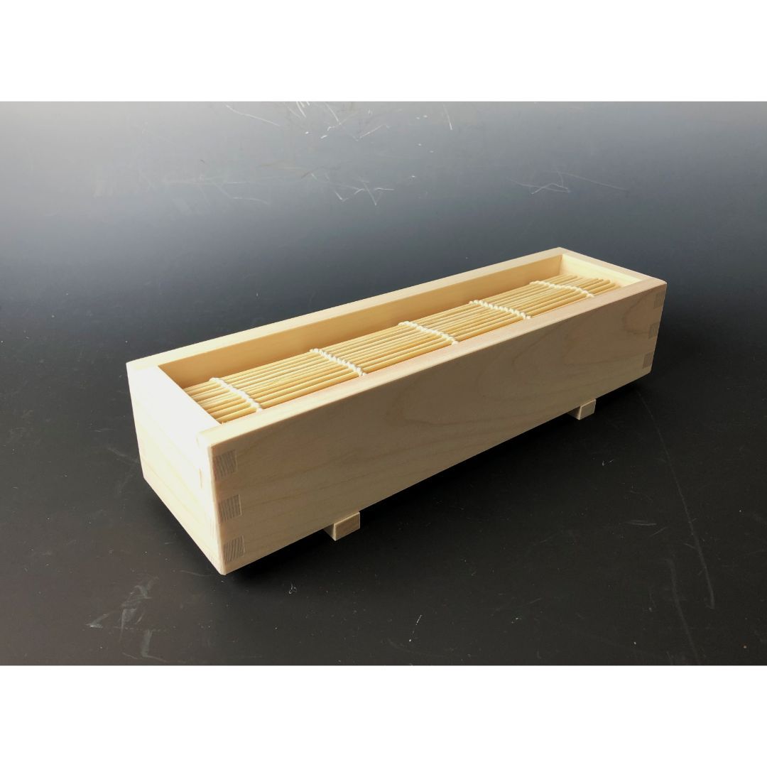 side view of a sushi kit maker bamboo tray grey background