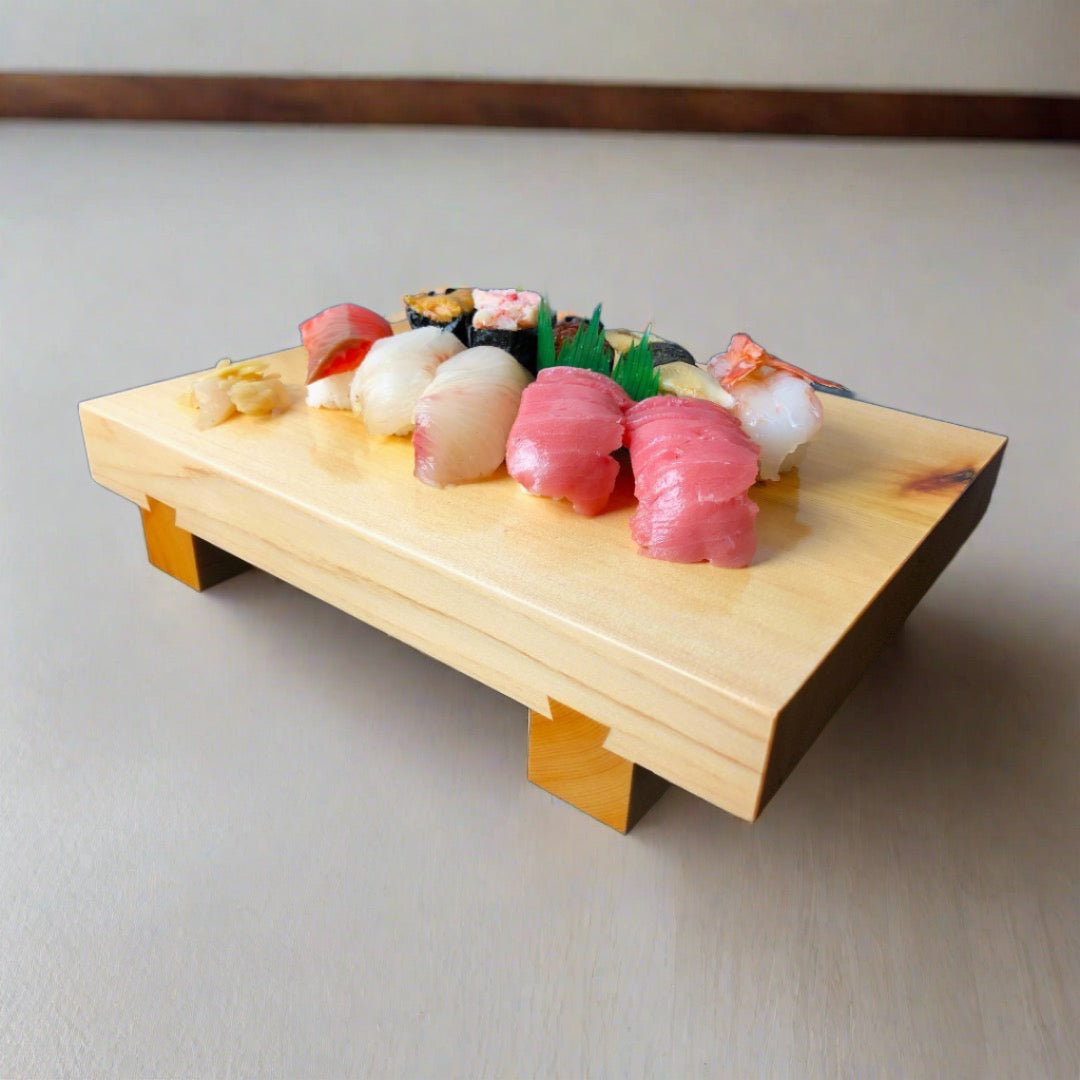 An image of a wooden sushi tray holding several pieces of sushi, set on a vibrant blue surface that is illuminated with blue light. The sushi pieces are artfully arranged on the tray and appear to be fresh and delicious. The contrasting blue light adds a modern and dynamic feel to the scene, while the natural wood of the tray provides a warm and organic touch.