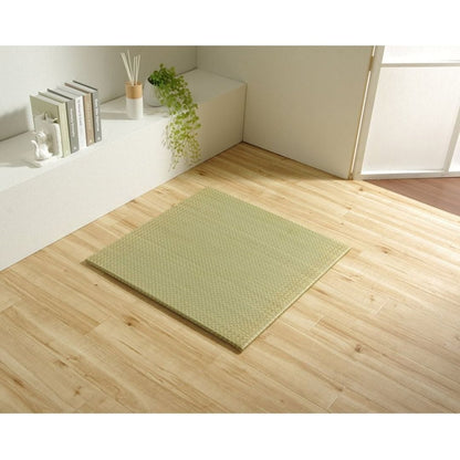 one square tatami on awooden floor with open window and books on a shelf