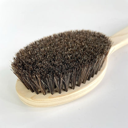 A wooden bath brush with black horse hair and hinoki wood