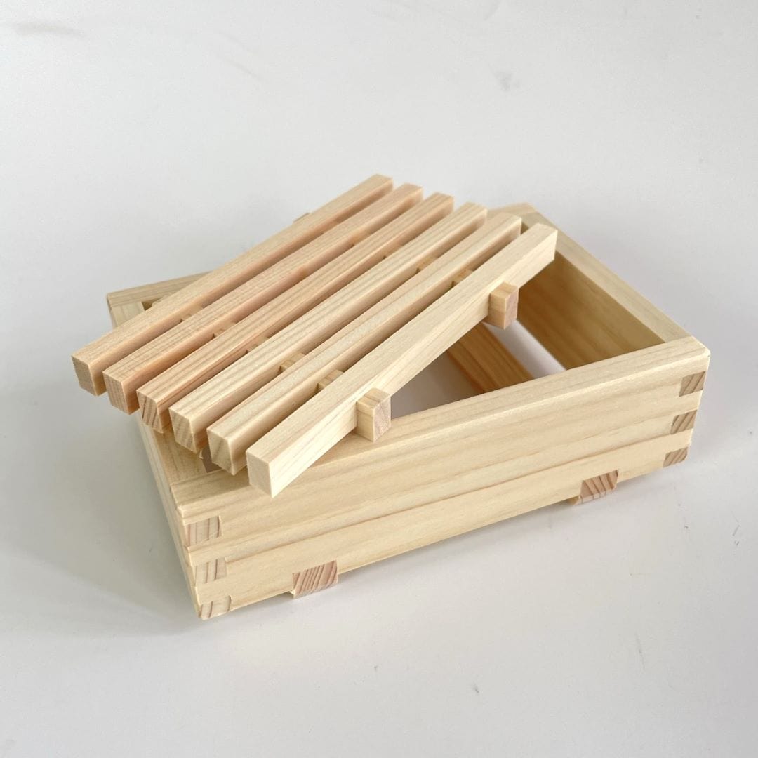 A wooden soap dish with the bottom part separated and resting on the tray.
